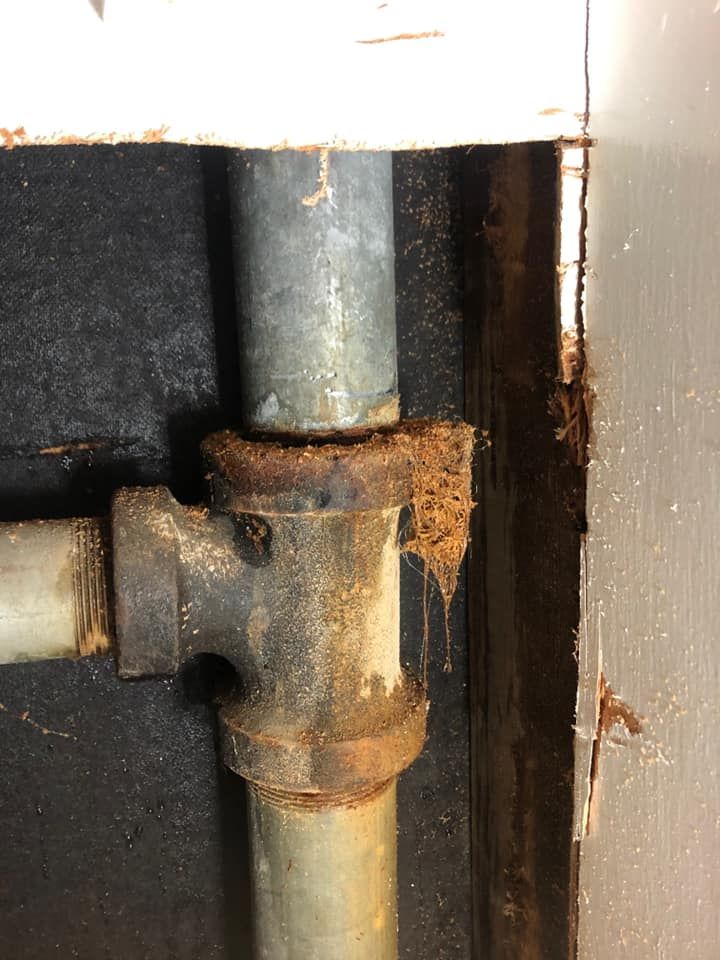 The old galvanized steel fitting, rusted and leaking