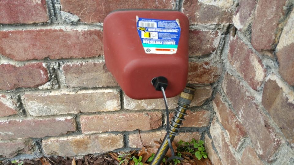 The faucet cover in place on the brick wall