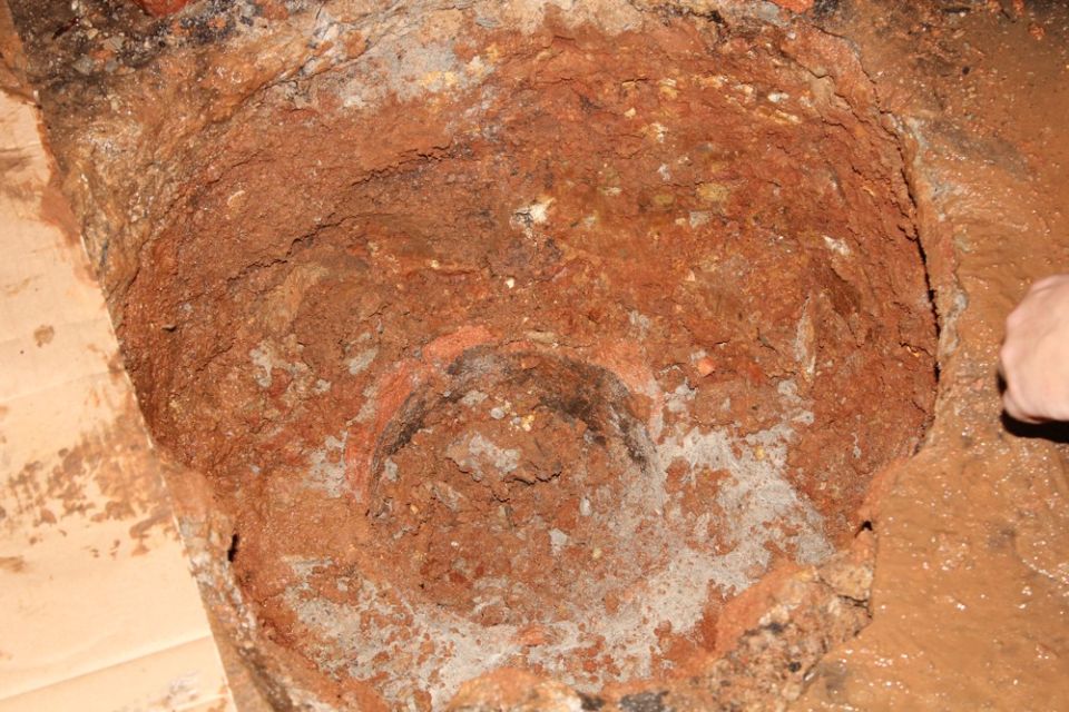 The dug-out pit in the red clay