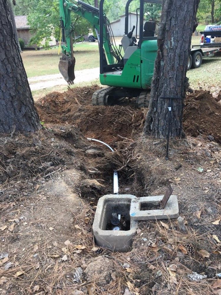 The meter box and the dig between the trees, with a mini excavator behind